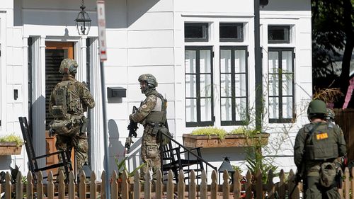 Armed police carry out door-to-door inquiries after the latest Florida shooting on Tuesday. (Photo: AP).