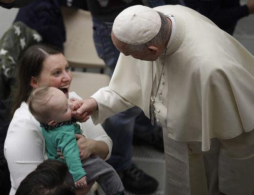 The Pope greets a baby in the Paul VI Hall at the Vatican during the last Wednesday's weekly general audience. (AAP)
