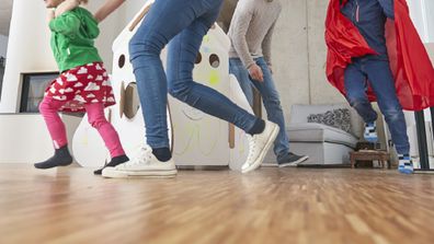 Children and their parents running around at home.