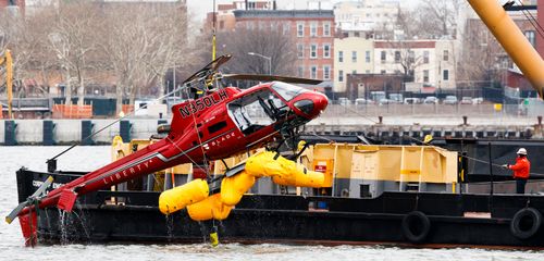  A crane lifts the sightseeing helicopter that crashed on Sunday night from the East River in New York. (AP)