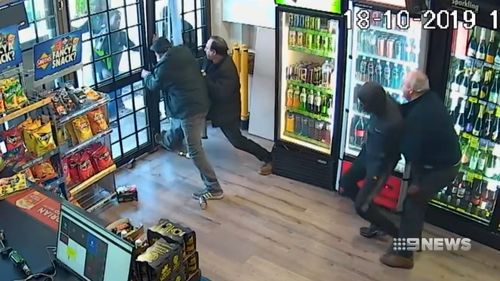 A Melbourne grandfather has risked his life, fighting off armed robbers at his family bottle shop while police took almost half an hour to arrive.