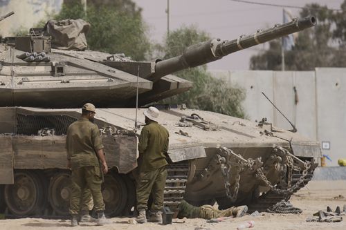 Israeli soldiers work on a tank at a staging area near the border with the Gaza Strip, in southern Israel, Tuesday, July 1, 2025. 