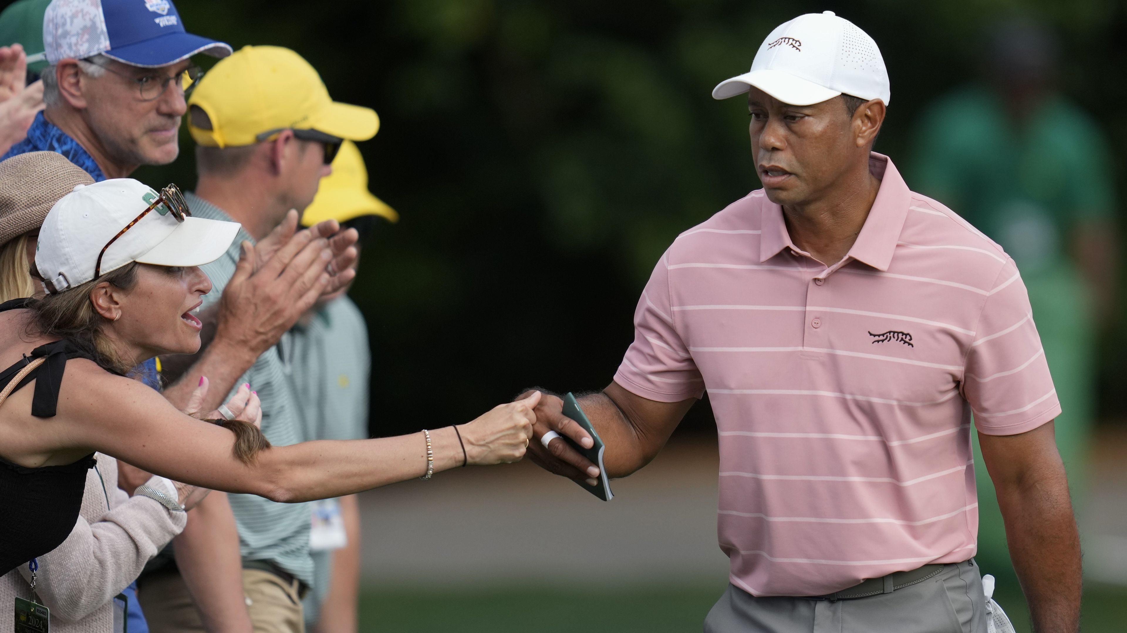 Tiger Woods greets a patron on the sixth hole.