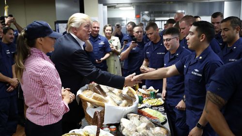 President Donald Trump, with first lady Melania Trump, greets and hands out sandwiches to members of the U.S. Coast Guard. (AP)