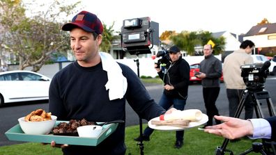 New Zealand Labour Party leader Jacinda Ardern's partner Clarke Gayford delivers home cooked food to the media waiting outside their house on October 17, 2020 in Auckland, New Zealand