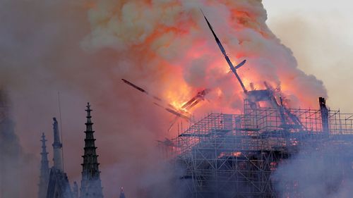 The spire leaned to one side and tumbled onto the burning frame of the building below.