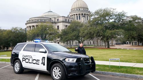 A Capitol Police officer warns off passersby as they respond to a bomb threat at the Mississippi State Capitol in Jackson on Wednesday morning.