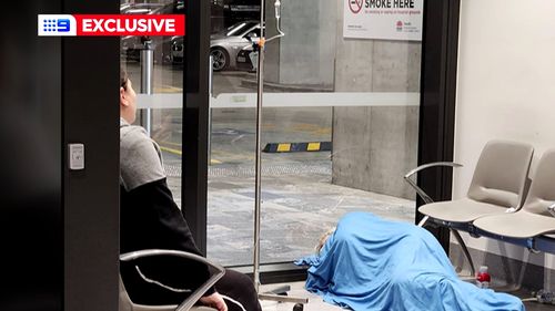 A sick patient receiving fluid intravenously on the floor of Westmead Hospital.