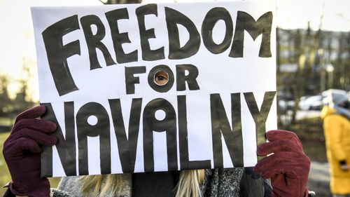 A demonstrator holds a poster outside the Russian embassy in Stockholm, Sweden, Saturday Jan. 23, 2021, during a protest demanding the release of Russian opposition leader Alexei Navalny.