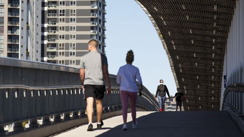 Residents walk over a bridge in Brisbane.