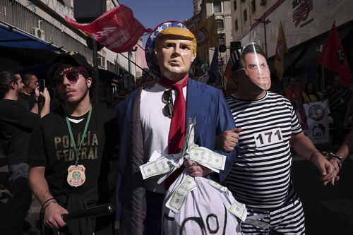 Brazil's former President Jair Bolsonaro is surrounded by the press as he leaves the Secretariat of Penitentiary Administration where he arrived after the Supreme Court ordered him to be fitted with an electronic ankle monitor in Brazil.