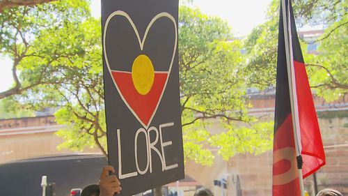 Protesters carried placards and waved the Aboriginal flag. 