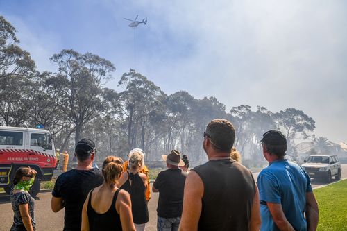 The NSW RFS has reduced the threat level to 'Advice' as fire crews continue to battle the blaze. (AAP)