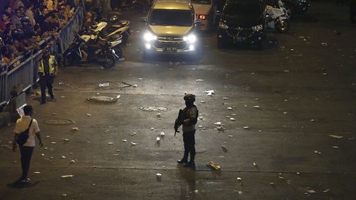 A police officer stands guard near the site of an explosion in Jakarta. (AAP)