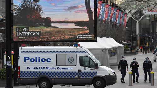NSW Police patrol alongside a NSW Police mobile command unit parked at the Liverpool mall in Sydney.