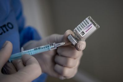 A healthcare worker of the Italian Army prepares doses of the AstraZeneca COVID-19 vaccine.