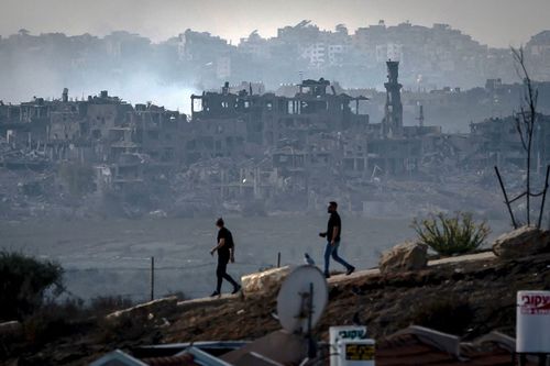 Men walk along the border of Gaza in southern Israel 