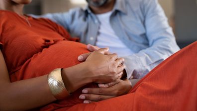 Pregnant couple on sofa