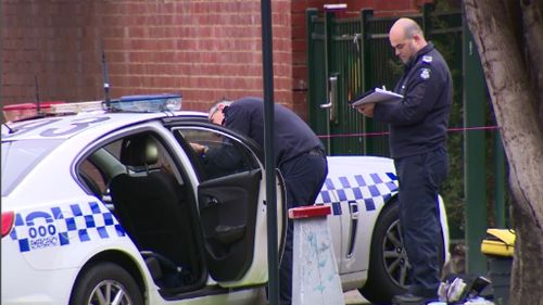 Forensic police examine the car driven by the police officer who was shot. (9NEWS)