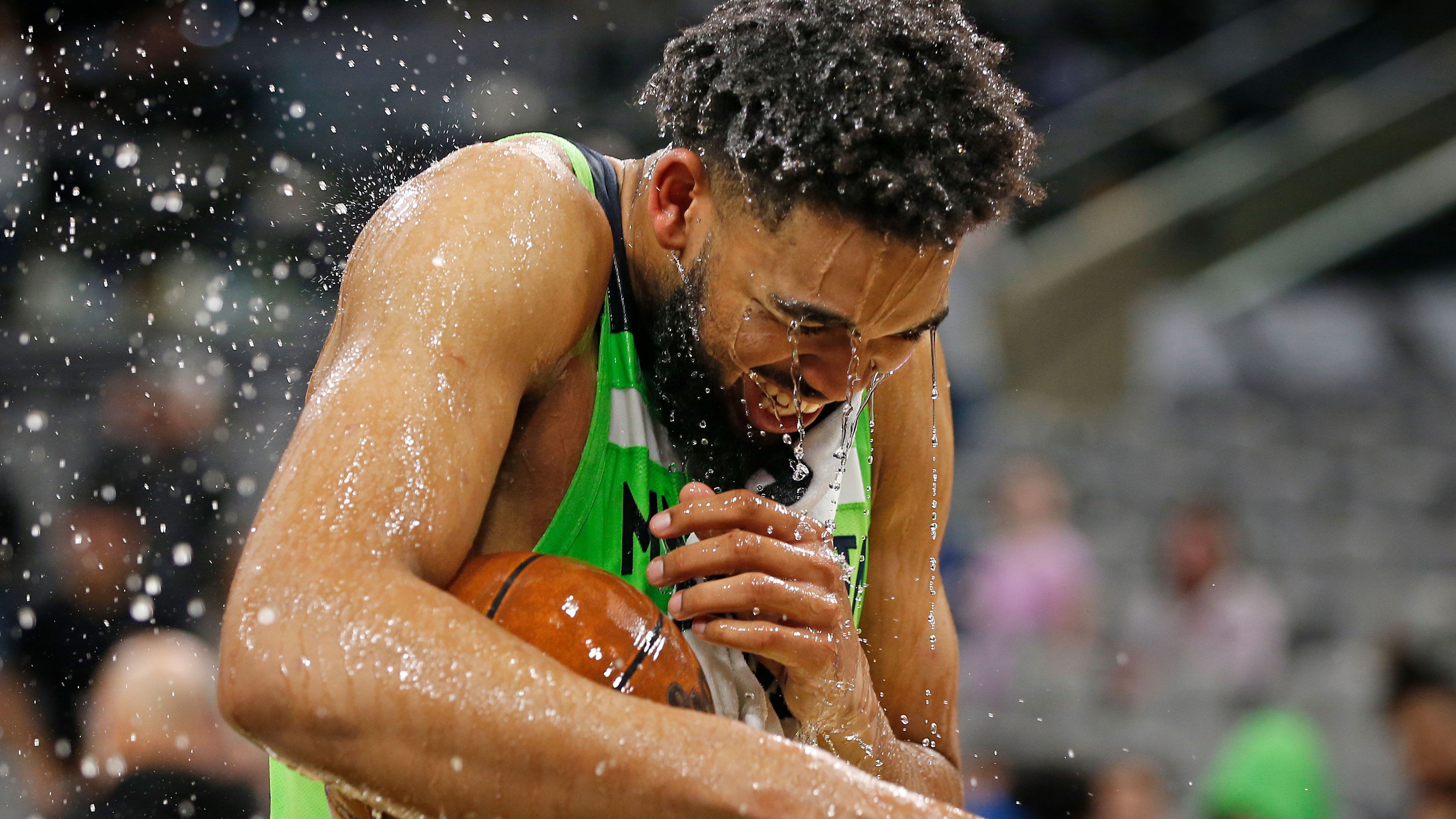 Karl-Anthony Towns #32 of the Minnesota Timberwolves gets a water bath after scoring 60 points against the San Antonio Spurs at AT&amp;T Center. 