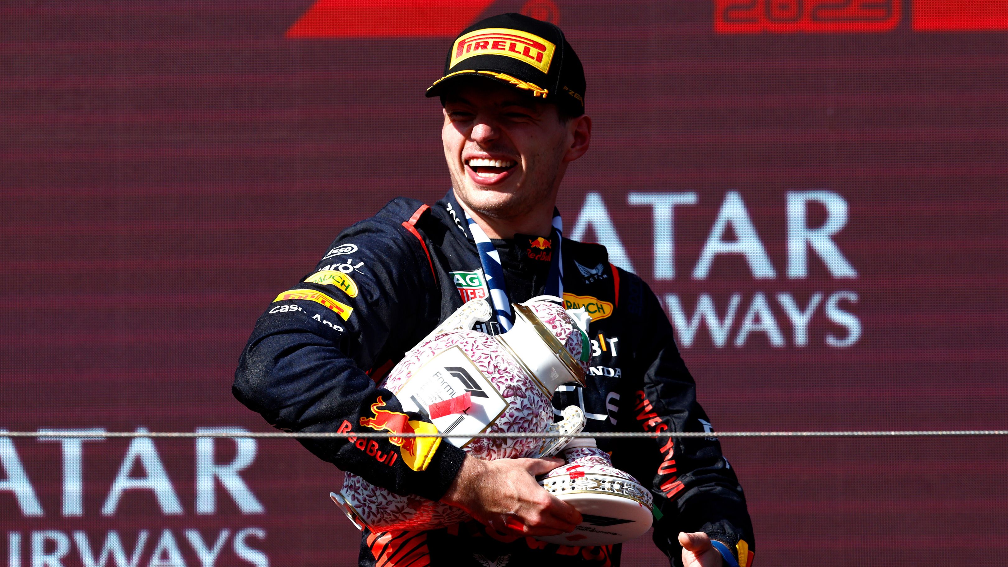 Max Verstappen carries the remains of his trophy after it was smashed during podium celebrations.