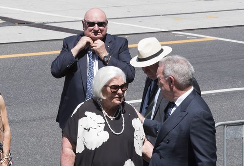 Businessman Lindsay Fox (left) ties his tie up on arrival to the state funeral service for Ron Walker. (AAP)