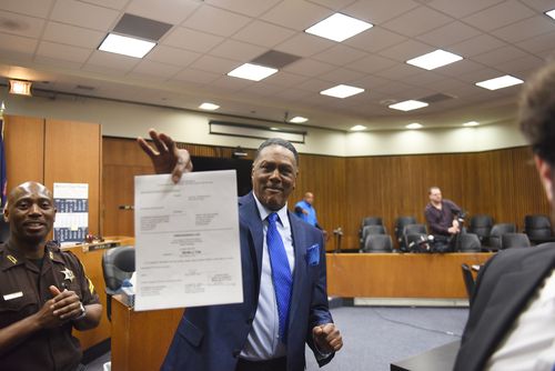 Richard Phillips shows his order of dismissal of homicide charges against him in Judge Kevin Cox's courtroom at the Frank Murphy Hall of Justice in Detroit on Wednesday, March 28, 2018. 