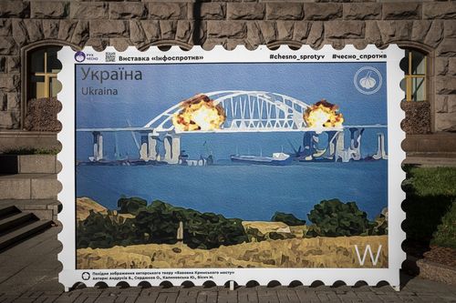 A picture of a postage stamp showing an artists impression of the Kerch bridge on fire.