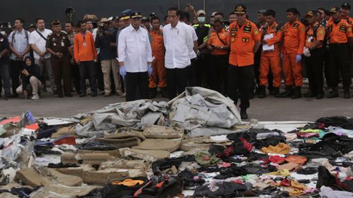 Indonesian President Joko Widodo views debris collected after the two-month-old plane plummeted into the ocean. 