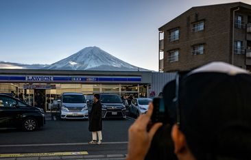 A tourist takes a photo at the spot in Fujikawaguchiko where the barrier is due to go - Japan Mt Fuji