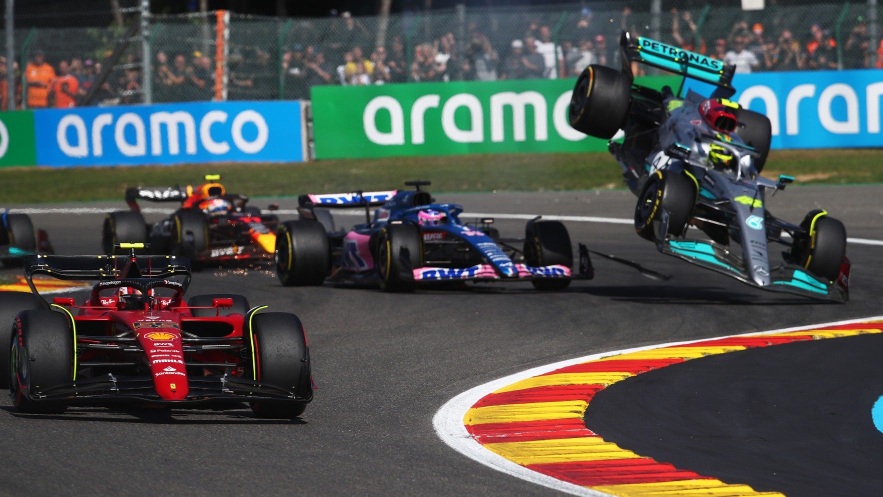 Carlos Sainz of Spain driving (55) the Ferrari F1-75 leads the field as Fernando Alonso of Spain driving the (14) Alpine F1 A522 Renault and Lewis Hamilton of Great Britain driving the (44) Mercedes AMG Petronas F1 Team W13 crash during the F1 Grand Prix of Belgium 