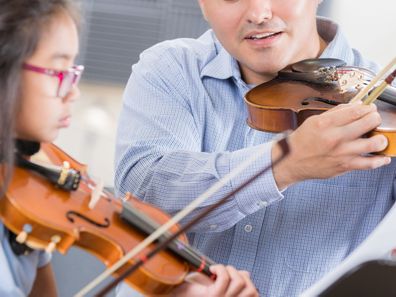 Man teaching girl violin