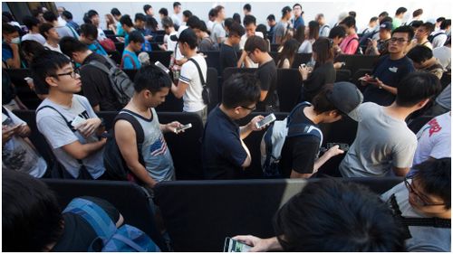 Customers queue up outside the Apple store in Hong Kong's Causeway Bay district. (AAP)