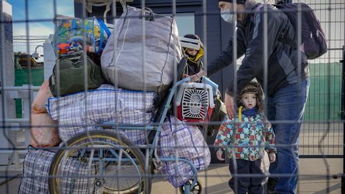 A family crosses from pro-Russian separatists controlled territory to Ukrainian government controlled areas in Stanytsia Luhanska.