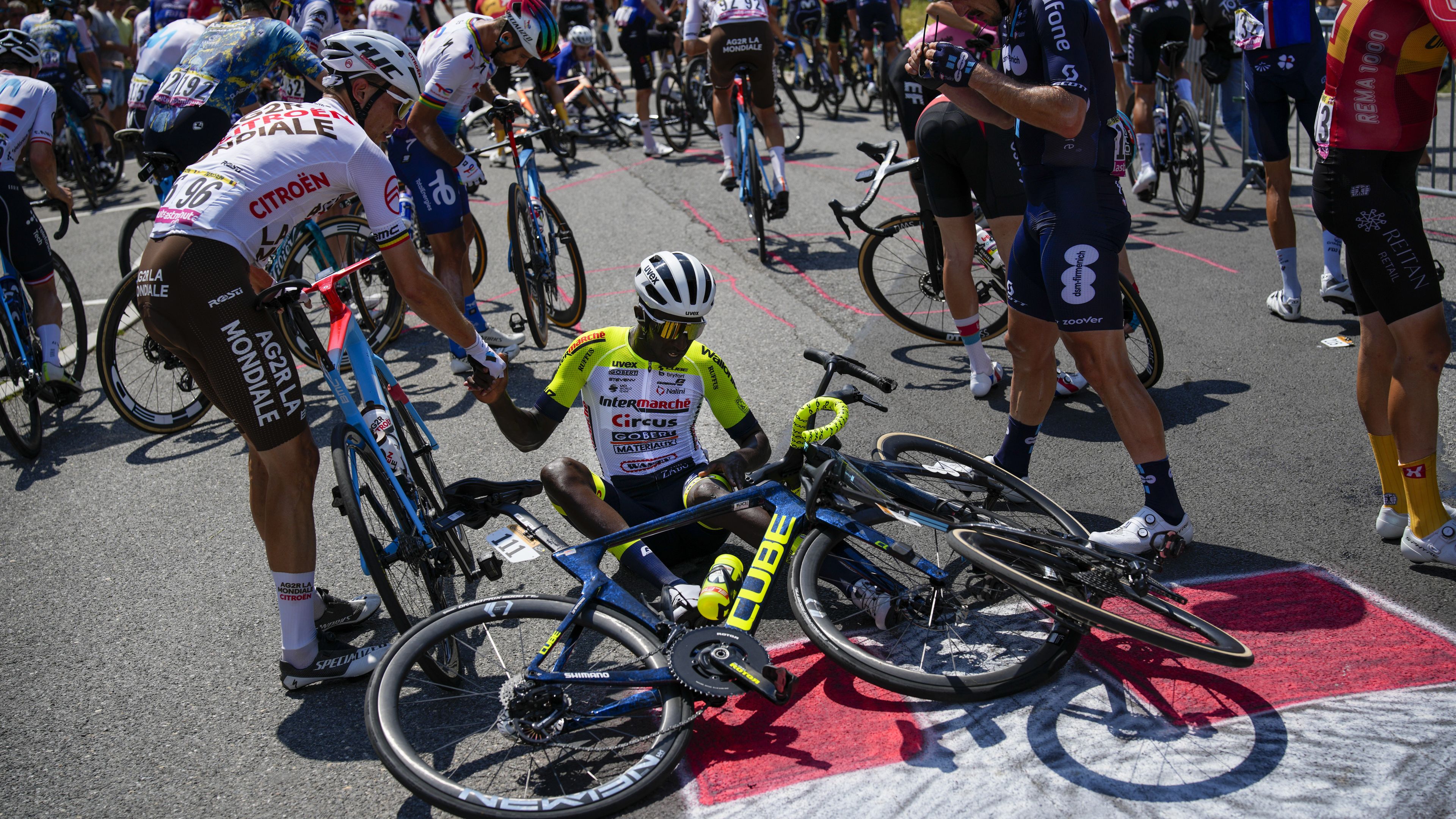 Eritrea&#x27;s Biniam Girmay gets a helping hand from Belgium&#x27;s Olivier Naesen after crashing during the 15th stage of the Tour de France.