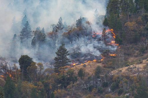 Southern California's huge wildfire roared to life again today in a mountain wilderness area even as many neighbourhoods were reopened to thousands of residents who fled its advance last week.