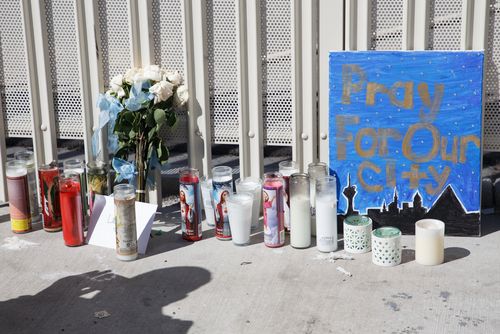 Candles, flowers and signs line the sidewalk near the Stratosphere Tower as part of a makeshift memorial to the victims of the mass shooting. (AAP)