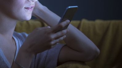 Woman using smart phone at night