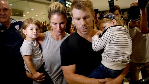 David Warner is accompanied by his wife, Candice, and children as he arrives back in Australia. (AAP)