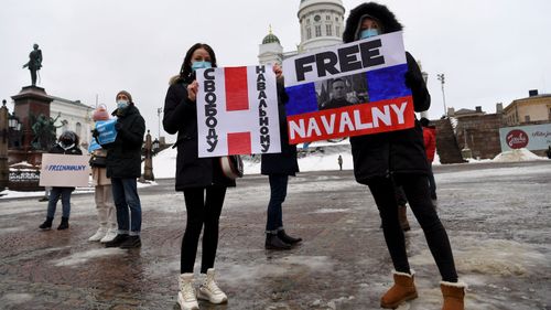 Demonstrators hold posters in Helsinki, Finland, Saturday Jan. 23, 2021, during a protest demanding the release of Russian opposition leader Alexei Navalny. 