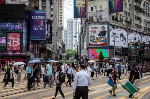 Pedestrians cross a busy street in Hong Kong.