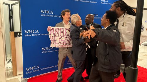 Protesters are forcibly removed from the red carpet at the White House Correspondents Dinner, Saturday, April 25, 2026, in Washington. 