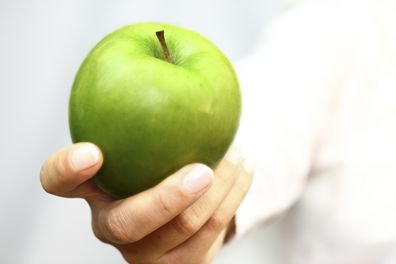 Green apple in hand