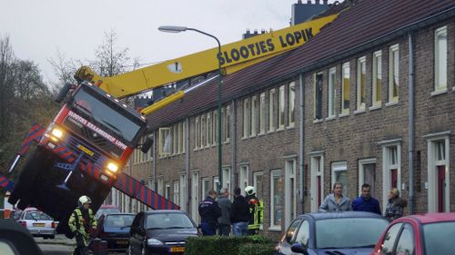 The man jumped to safety as the crane toppled into homes. (AAP)