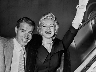 Joe DiMaggio and Marilyn Monroe as they board plane during their honeymoon to Japan in 1954. Marilyn Monroe is wearing a strand of pearls by Mikimoto, a wedding present from her husband.