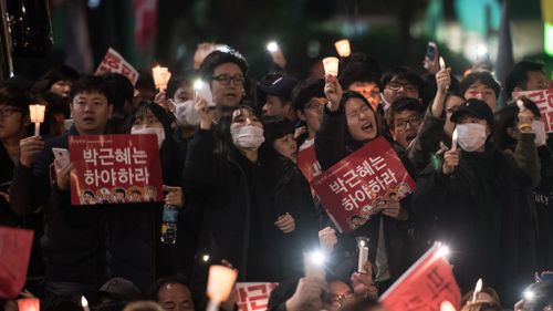 Protesters hold placards and shout slogans calling for the resignation of South Korean President Park Geun-Hye in central Seoul on November 12, 2016. (AFP)