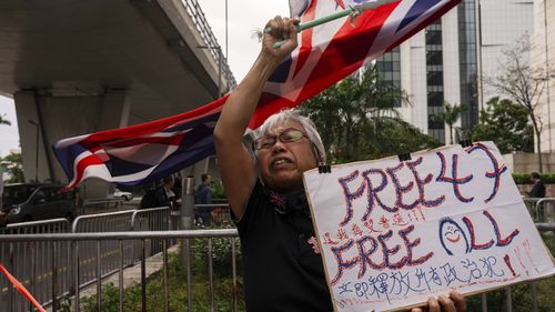 FILE- A pro-democracy activist known as "Grandma Wong" protests outside the West Kowloon courts in a cordoned off area set up by police as closing arguments open in Hong Kong's largest national security trial of 47 pro-democracy figures in Hong Kong, Nov. 29, 2023. (AP Photo/Louise Delmotte, File)