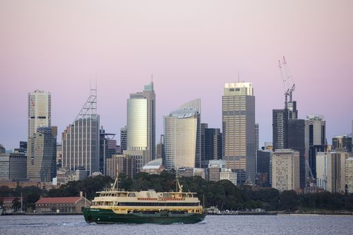Sydney welcomes a brand new day as the first rays of light hit the buildings in the CBD, as seen from Bradleys Head, Mosman. The Manly Ferry makes it's from journey Circular Quay to Manly.