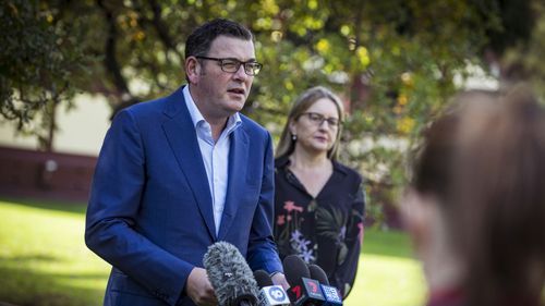 Premier Daniel Andrews speaking to reporters in a park in Melbourne.