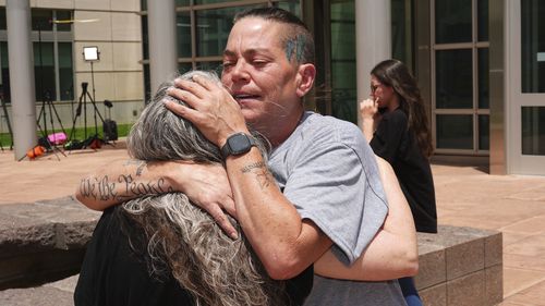 Crystina Page, right, hugs Beth Mosley, who both had retained the services of a Colorado funeral home owner who stashed nearly 190 decomposing bodies, after the owner was sentenced to 20 years prison on federal fraud charges, Friday, June 27, 2025, in Denver. (AP Photo/David Zalubowski)